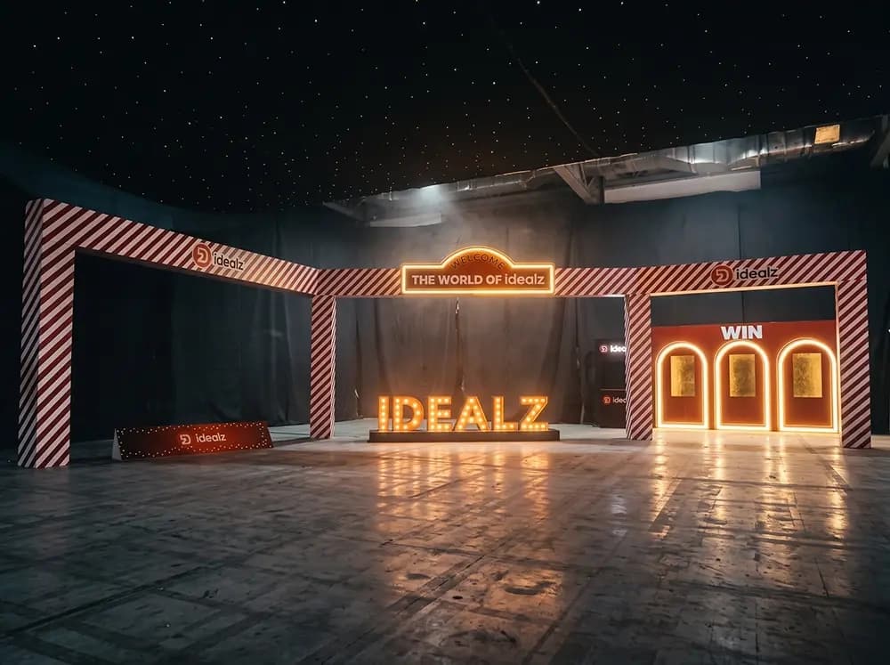 Idealz Christmas event set with a striped portal and illuminated marquee letters built by Proink