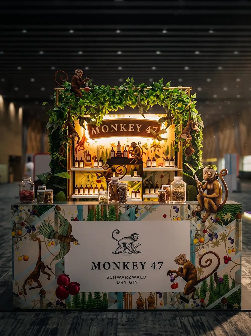 Monkey 47 gin bar activation with illuminated signage and botanical styling built by Proink