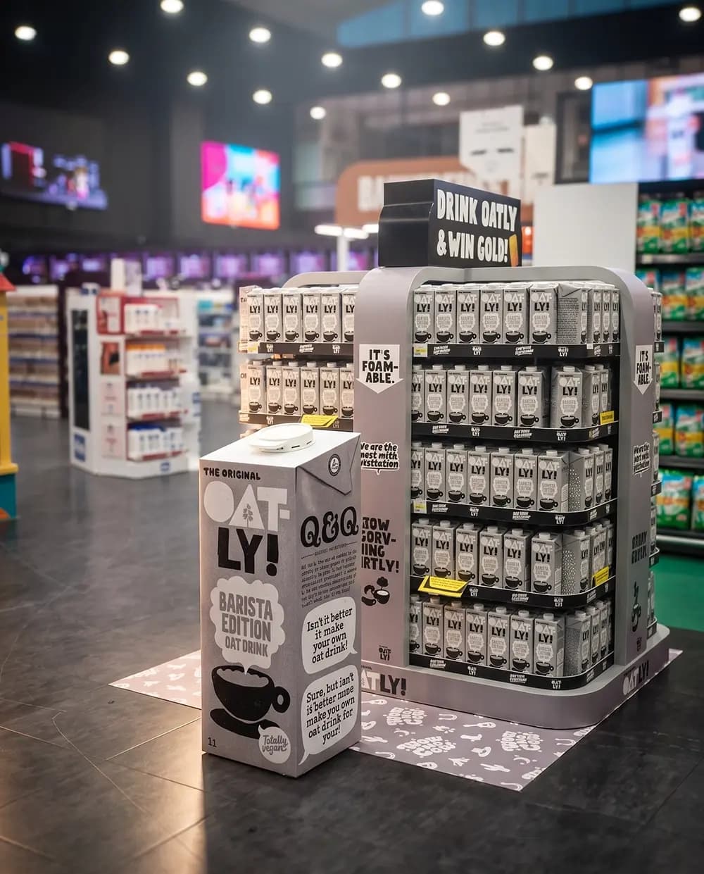 Oatly Barista display unit stocked in a supermarket aisle with an oversized carton replica