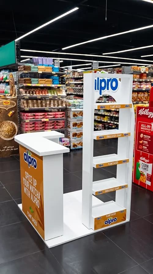 Alpro display shelving with printed category strips installed in a store aisle