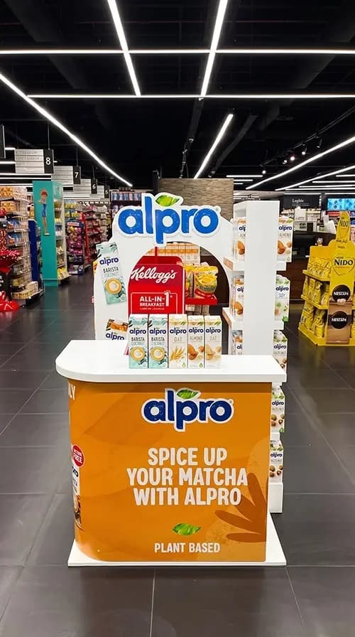 Alpro counter displaying the plant-based drink range in a supermarket aisle