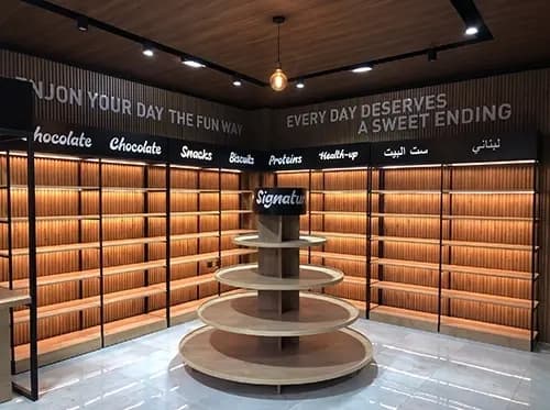Freestanding timber display unit and backlit shelving inside the candy shop
