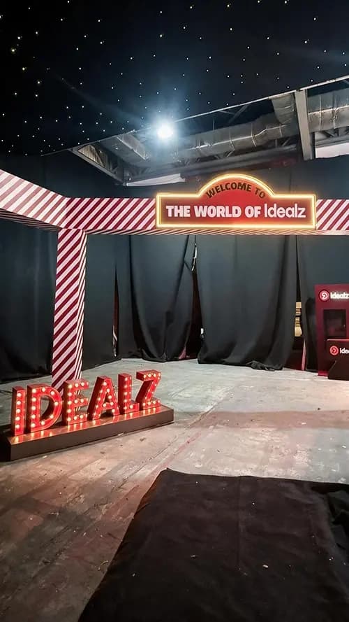 Welcome to the World of Idealz marquee sign above giant illuminated letters