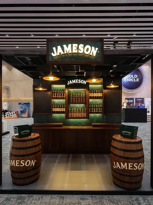 Jameson bar with a green backlit bottle display and warm pendant lighting