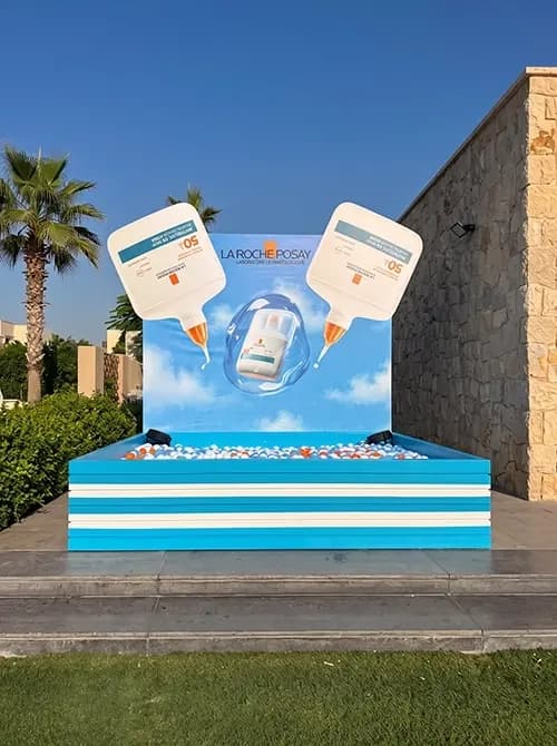 Anthelios photo set with a striped ball pit platform and oversized product cutouts
