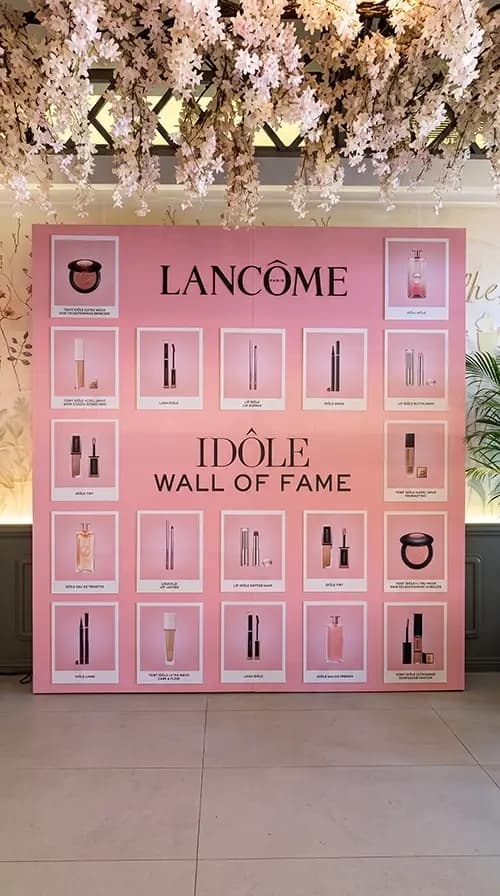Lancôme Idôle Wall of Fame with framed product panels on a pink display wall