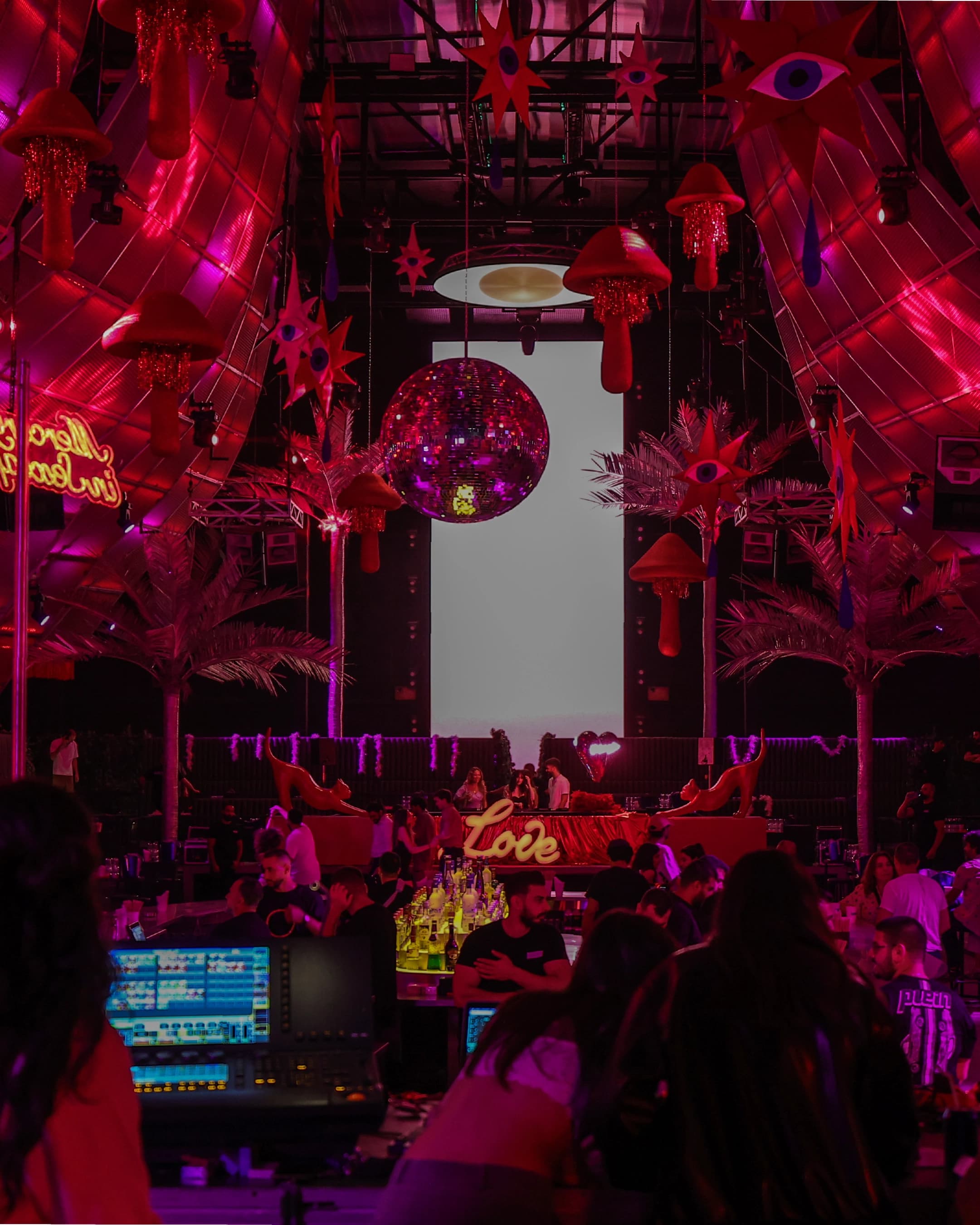 Crowd inside the Absolut Love Night venue with neon installations and staging