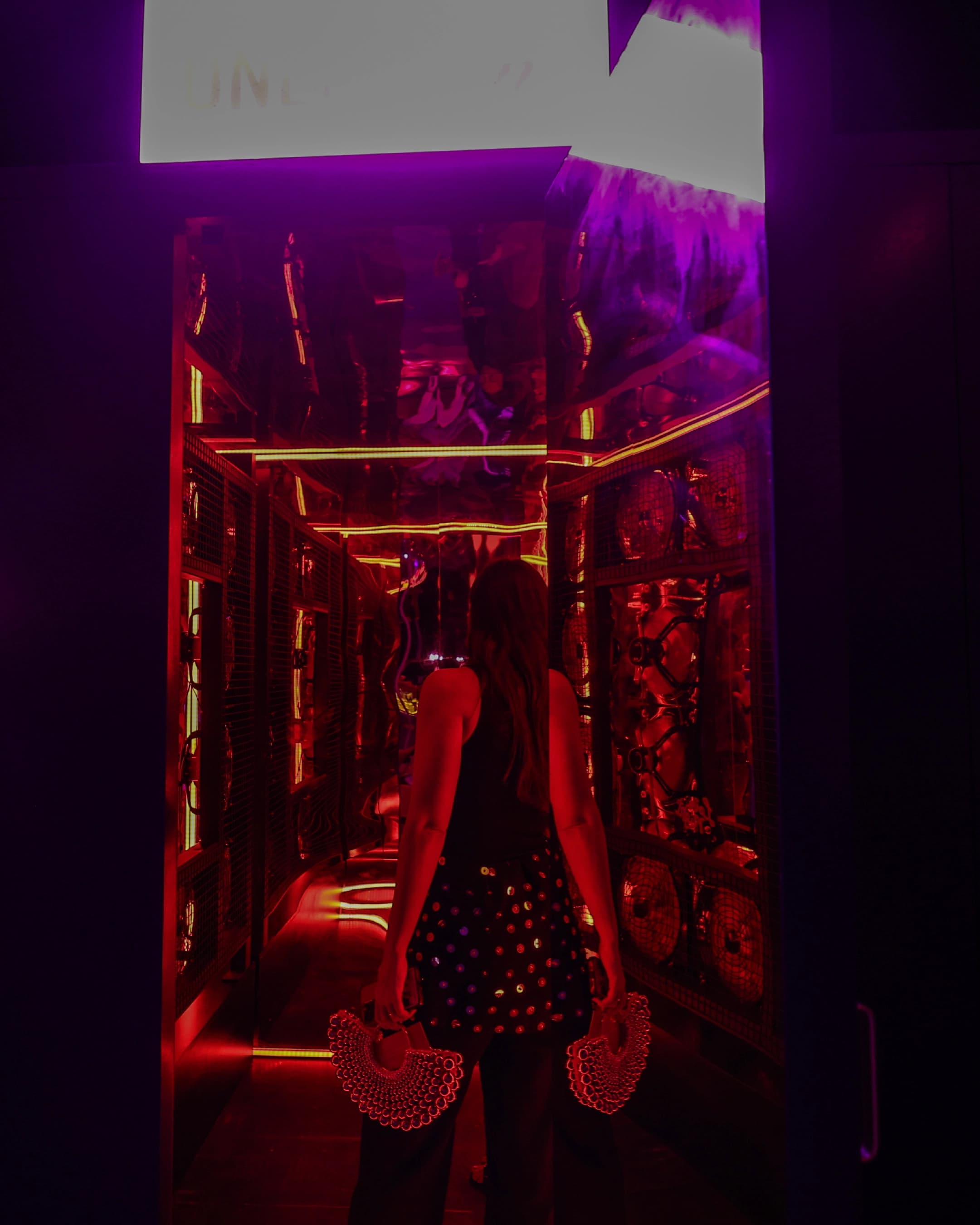 Guest walking through a mirrored neon corridor at Love Night