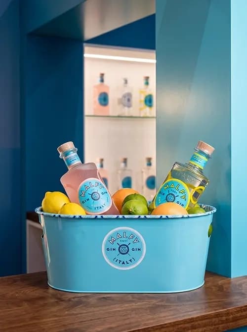 Branded Malfy Gin ice bucket filled with citrus and bottles
