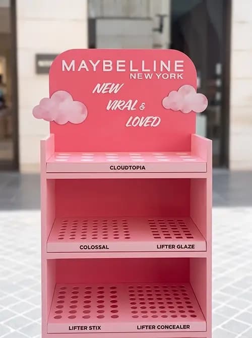 Maybelline retail display unit with cloud props and labelled product shelves