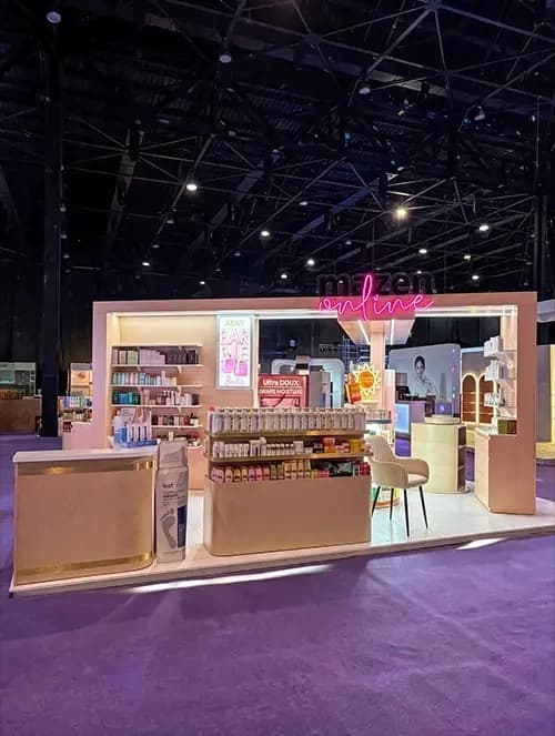 Full view of the Mazen Online exhibition stand with product shelving and consultation seating