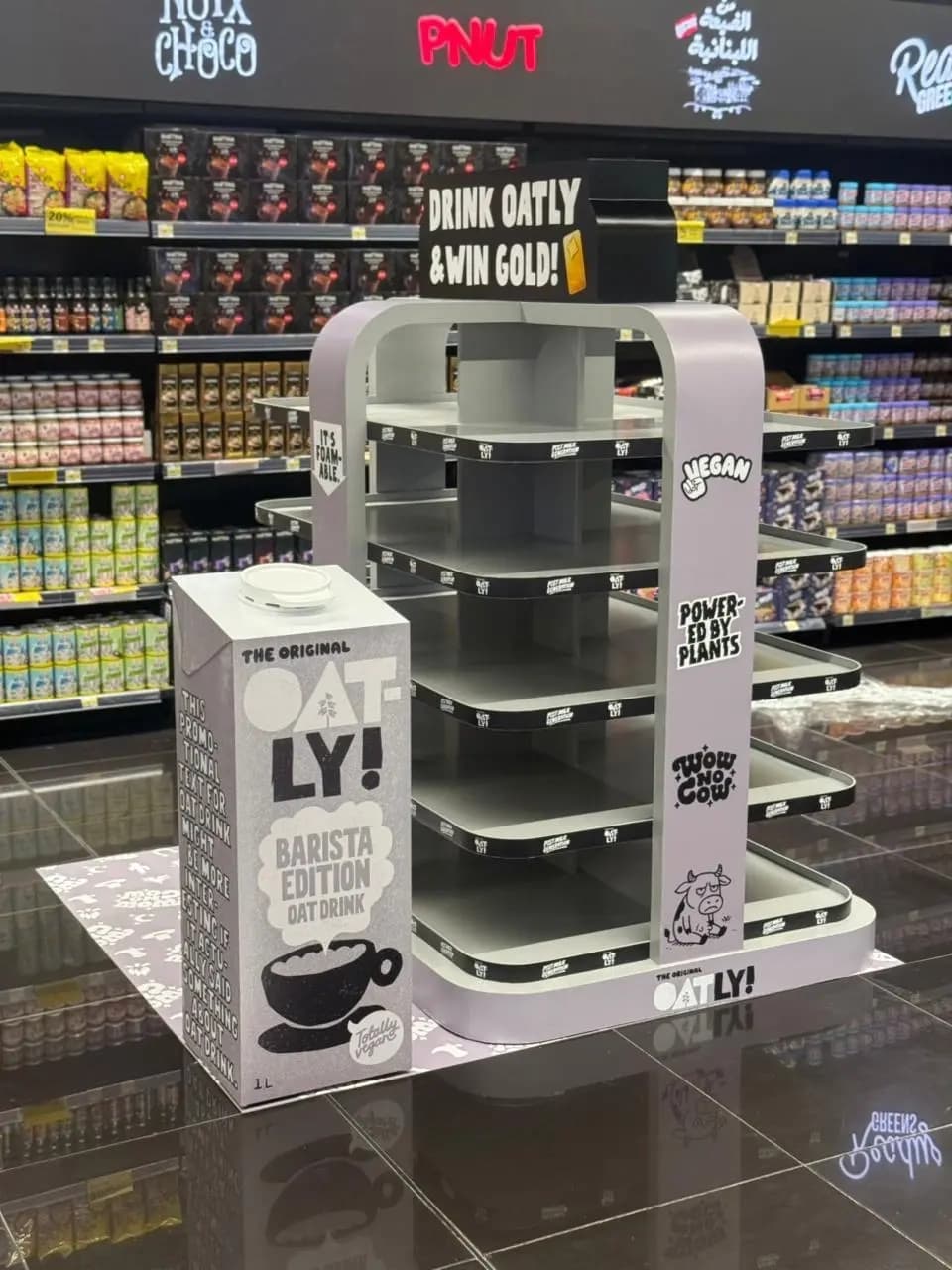 Empty Oatly display unit showing the arch structure and tiered stock trays