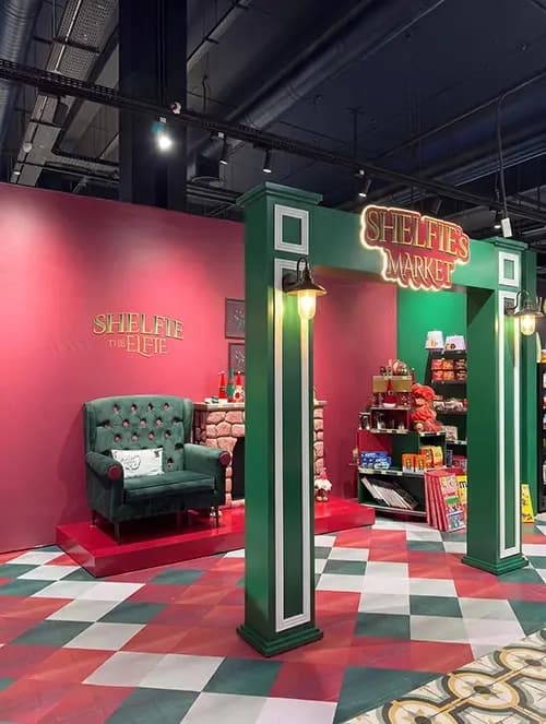 Christmas fireplace set piece with a green armchair inside the Spinneys activation